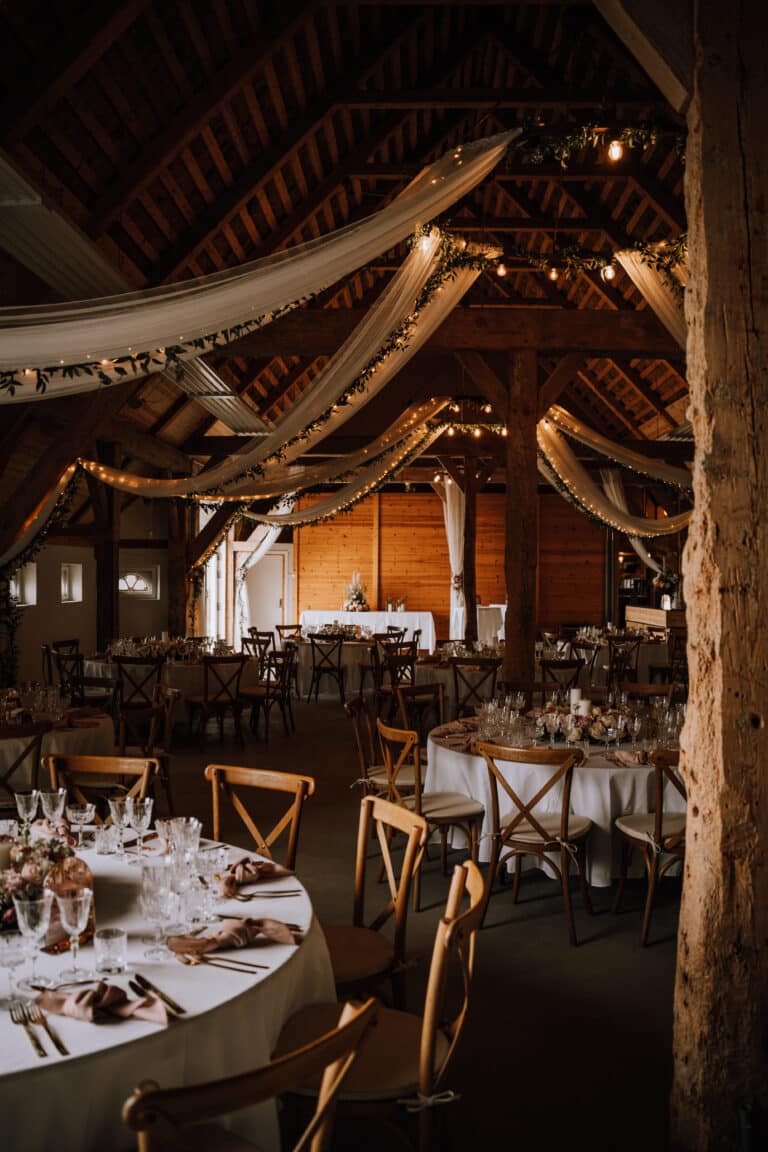 En rustik bryllupsreception i en lade med borde og stole