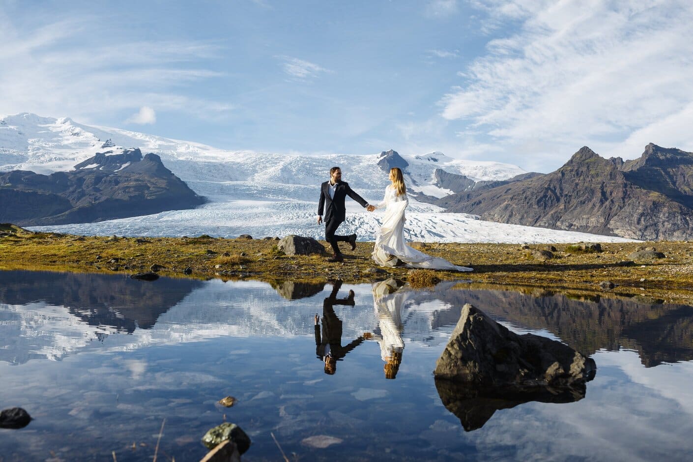 Et brudepar, der står foran en norsk gletsjer.